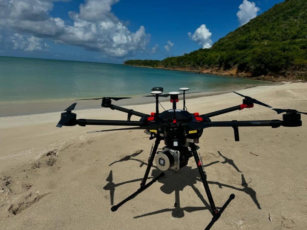 a tripod on top of a sandy beach next to a body of water