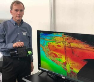 A Man Standing In Front Of A Monitor